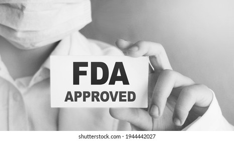 FDA Approved words on card Doctor shows. Food and Drugs Association approved products concept.
