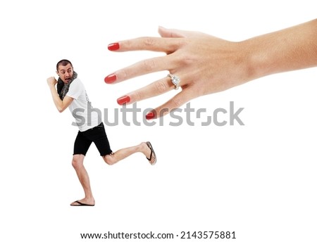 Fear of commitment. A young man trying to run away from a giant hand wearing a wedding ring.