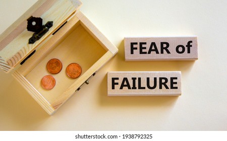Fear of failure symbol. Wooden blocks with words 'fear of failure'. Beautiful white background, copy space. Small chest with coins. Business, fear of failure concept.
