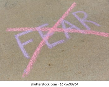 Fear Written With Sidewalk Chalk And Crossed Out