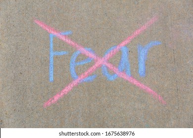 Fear Written With Sidewalk Chalk And Crossed Out