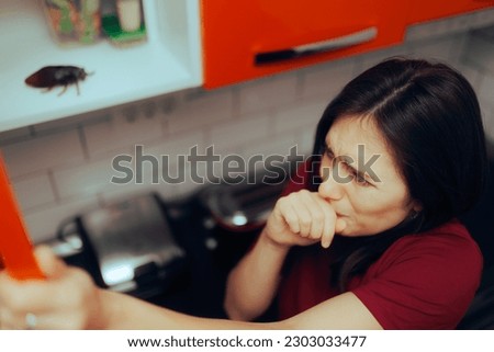 
Fearful Woman Opening a Cabinet Finding a Big Roach. Girl panicking after discovering a huge insect indoors

