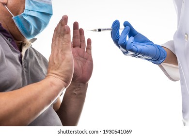 Fearful worried middle age man reacting to medical practitioner holding syringe loaded with Covid-19 vaccine during vaccination program