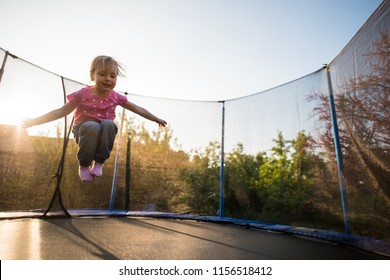 Fearless Child Jumping High On The Trampoline Bed