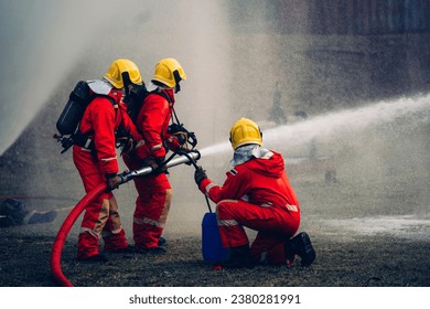 Fearless Firefighters Battling Blaze with Water and Extinguishers. Firefighters in Action, Extinguishing Fire with Teamwork and Courage. Intense Firefighting Training Exercise. - Powered by Shutterstock