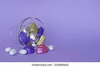 Feast Concept, Traditional Turkish Ramadan sweet sugar candy, and chocolates in glass bowl with purple background.