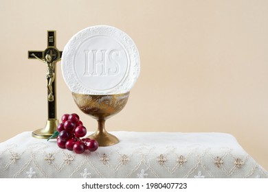 The Feast of Corpus Christi Concept. Holy communion and cup of glass with red wine on table.