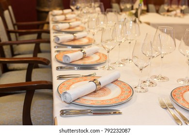 Feast, Treatment, Wedding Concept. Long Table Covered With White Cloth And Served For Reception Guests, There Are Shining Glasses For Alcohol And Decorated Tableware In Classic Style