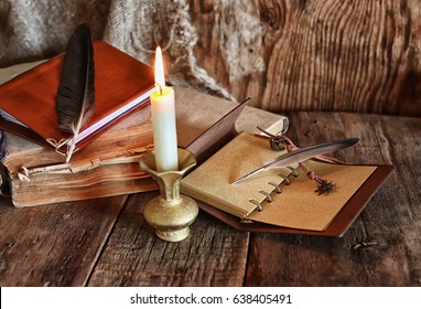 feather and book novel close to the a candle