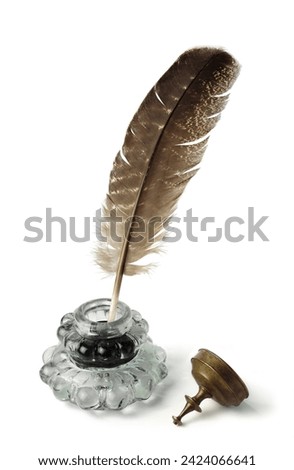 Feather with ink bottle. Calligraphy and beautiful vintage handwriting. Quill pen and bottle of ink.
