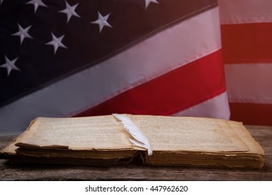 Feather On Open Book. USA Flag And Aged Book. History Teaches Us Important Things. Look Into The Bygone Era.