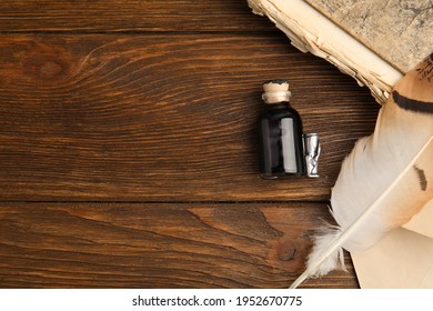 Feather Pen, Bottle Of Ink And Old Book On Wooden Table, Flat Lay. Space For Text