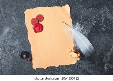 Feather Pen, Ink, Paper Sheet And Stamps On Table