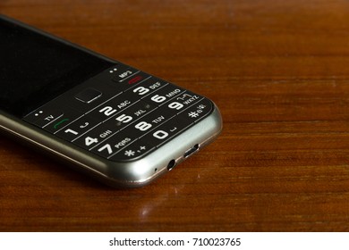 Feature Phone On Wooden Board.