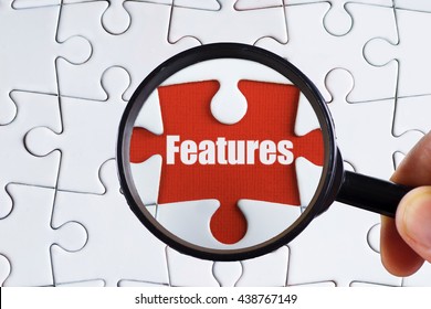 "Features" text on red missing jigsaw puzzle with man right hand hold black magnifying glass searching for missing puzzle peace - business and finance concept - Shutterstock ID 438767149
