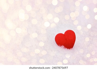 February 14 postcard,  red heart on the snow among blurry lights, space for text,
