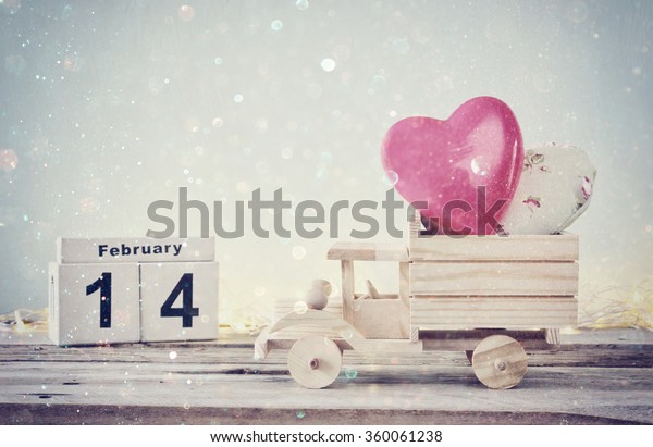 February 14th wooden vintage calendar with\
wooden toy truck with hearts. valentine\'s day celebration concept.\
vintage filtered with glitter\
overlay\
