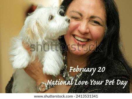 February 20 20th National Love Your Pet Day. Holiday. Middle aged Indigenous Native Metis woman. White dog. Maltese mix cross. Small breed. Holding. Kiss kissing. Smile smiling. Affection. Happiness.