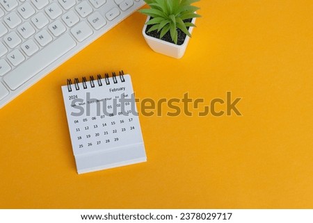 February 2024 desk calendar on yellow background. Directly above. Flat lay. Copy space.