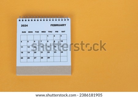 February 2024 desk calendar on yellow background. Directly above. Flat lay.