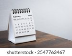 February 2025 calendar on the wooden table. Month page