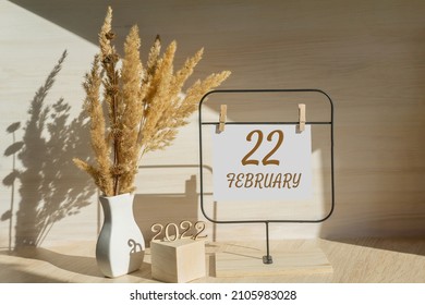 february 22. 22th day of month, calendar date. White vase with dead wood next to the numbers 2022 and stand with an empty sheet of paper on table. Concept of day of year, time planner, winter month. - Shutterstock ID 2105983028