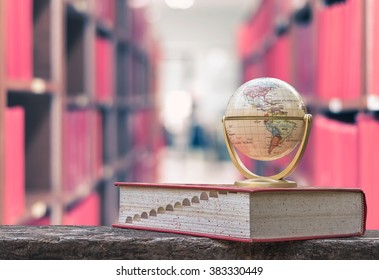 FEBRUARY 26, 2016 - BANGKOK, THAILAND: Globe model on textbook, or dictionary on  table in school or university library, educational resource for knowledge