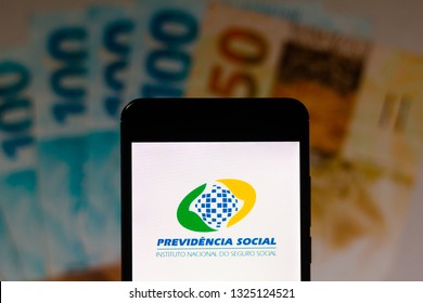 February 27, 2019, Brazil. Social Security Logo (INSS) Displayed On The Screen Of The Mobile Device. Money Notes In The Background. Concept Of Retirement, Pension And Rights.