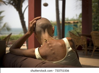 February 28, 2010 - Mandrem, Goa, India. The Bald Yoga Woman, Sitting From The Back, In Front Of Arabian Sea.
