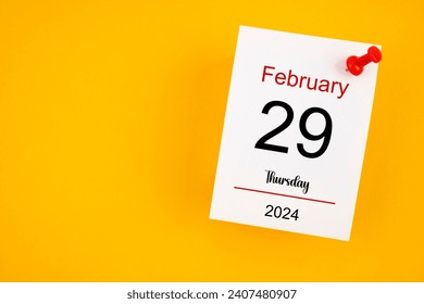 February 29th calendar for February 29 and wooden push pin on yellow background. Leap year, intercalary day, bissextile.