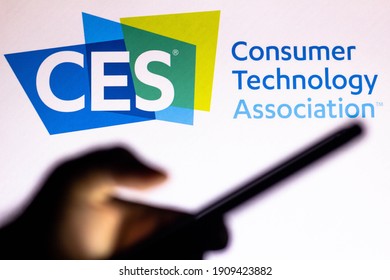 February 4, 2021, Brazil. In This Photo Illustration The Consumer Electronics Show (CES) Logo Seen In The Background Of A Silhouette Hand Holding A Mobile Phone