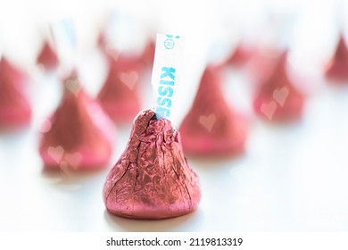 February 7, 2022 - Chicago, IL, USA: A horizontal shot of Hershey Kisses chocolate candy wrapped in pink foil for Valentine's Day. Defocused in the background are more of the chocolate candies.