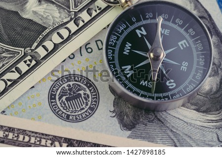 FED, Federal Reserve of US government direction on interest rate concept, compass on US Dollar banknote with Feral Reserve emblem.