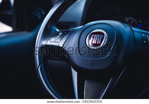 \
Brasília, Federal\
District - Brazil. June, 11, 2019. Photo of the interior of a car\
Fiat Pálio Weekend 1.8 model 2016. Highlight the vehicle steering\
wheel with a company\
logo.