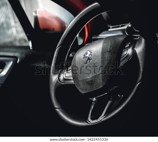\
Brasília,\
Federal Distritc - Brazil. June, 12, 2019. photo of the interior of\
a car peugeot 208 griffe1.6 automatic model 2014. Highlight the\
vehicle steering wheel with a company\
logo.