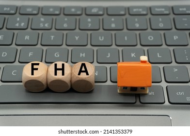 Federal Housing Administration (FHA) loan help low- to moderate-income families attain homeownership. word is written on dice, next to house.