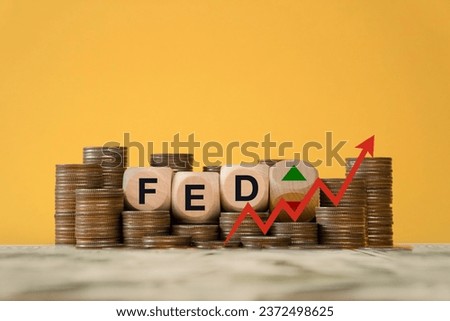 Federal Reserve (FED) to control interest rates. FED concept of interest finance. Wooden block on a coin with the abbreviation FED, American economy and business. The policy of raising interest rates