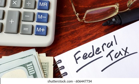 Federal Tax Written In A Notebook And Calculator.