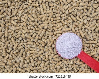 Feed Additive In Red Spoon On Blurred Animal Feed Background, Antibiotics In Animal Feed Concept.