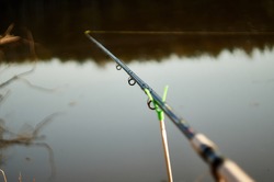 Feeder Fishing Rod On The Stand Against The Background Of The River. Closeup