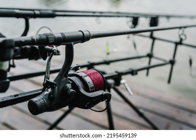 Feeder With Reel Close-up. Fishing Rods For Carp Fishing With Signaling Devices On The Holder. Rod Pod. Angler Is Fishing With Carp Fishing Technique.