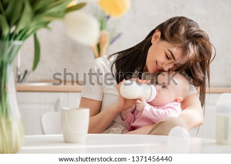 Feeding newborn girl with formula in a bottle.