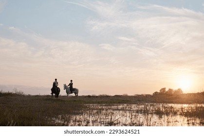 Feel the air, smell the foliage and explore natures beauty. Shot of two young women out horseback riding together. - Powered by Shutterstock