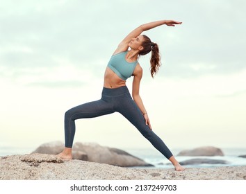 Feel The Positive Energy Flow Through Your Body. Shot Of A Sporty Young Woman Practicing Yoga At The Beach.