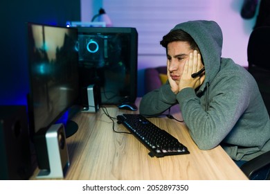 I'm Feeling So Bored. Tired Male Gamer With His Hands On The Chin And Tired After Playing Video Games On The Computer