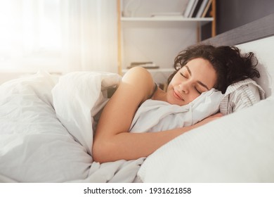Feeling calmness. Sleepy female keeping eyes closed while dreaming about future vacation or sleeping at the bedroom. Stock photo