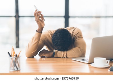 Feeling Exhausted. Frustrated Black Man Resting Head On His Hand After Difficult Conversation On Phone. Free Space