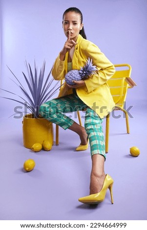 Feeling fruity. Full length studio portrait of an attractive young woman dressed in funky attire against a purple background.