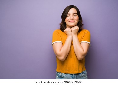 Feeling grateful. Pleased young woman feeling happy and thankful against a purple background - Shutterstock ID 2093212660