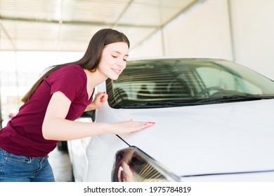 Feeling Happy And Proud Of My Work. Caucasian Young Woman Smiling And Checking If The Car Hood Is Clean After Washing It